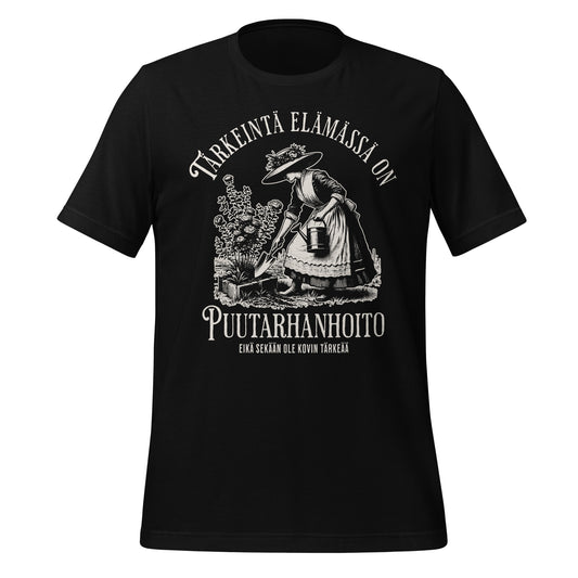 Musta t-paita, jossa teksti 'Tärkeintä elämässä on puutarhanhoito, mutta sekään ei ole tärkeää'. Kaunis vintage tyylinen piirroskuva. 